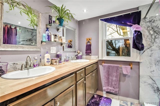full bathroom featuring a sink, walk in shower, and double vanity