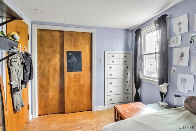 bedroom with multiple windows and light wood-style flooring