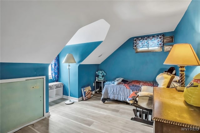 bedroom with baseboards, wood finished floors, and lofted ceiling