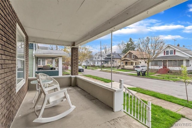 balcony featuring covered porch and a residential view