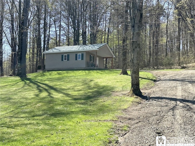 single story home with metal roof, a front yard, and covered porch