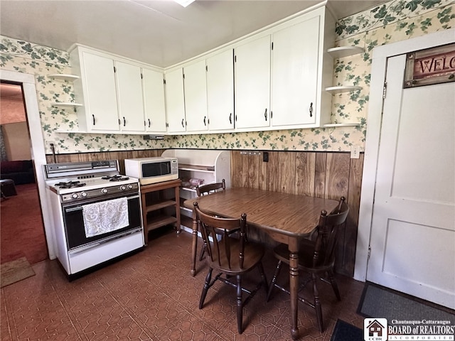kitchen featuring white cabinetry, wallpapered walls, white appliances, and open shelves