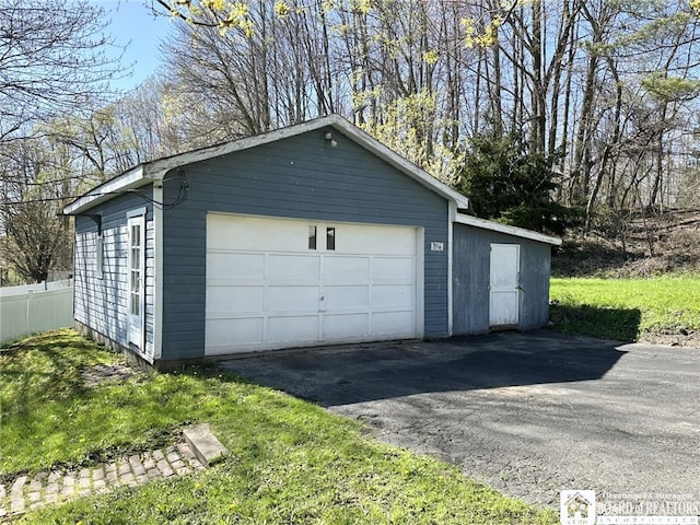 detached garage featuring fence
