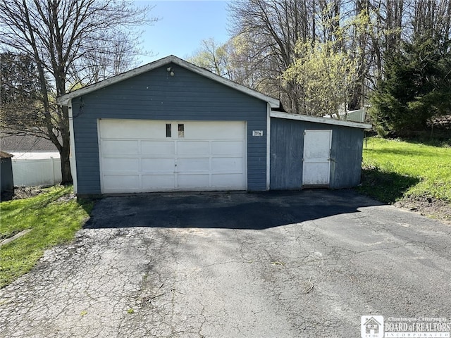 detached garage featuring fence