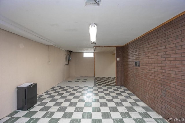 basement with tile patterned floors and brick wall