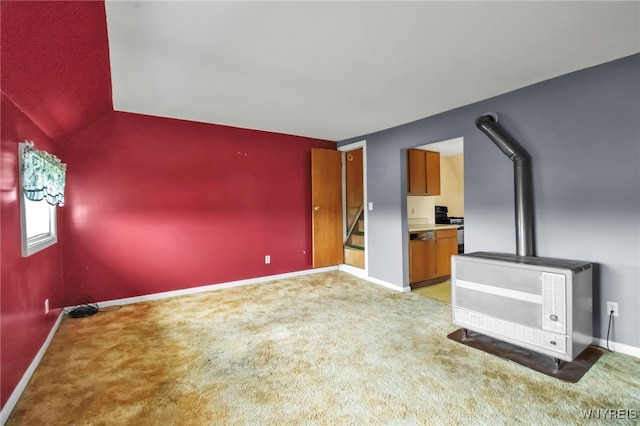 unfurnished living room featuring heating unit, light carpet, and baseboards