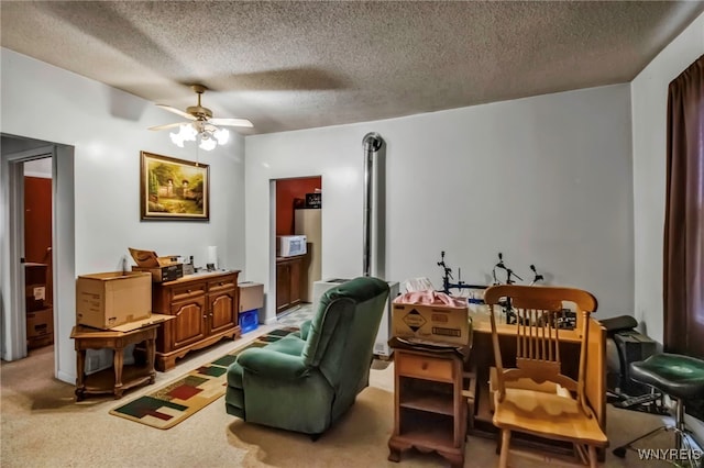 living area featuring a ceiling fan, light colored carpet, and a textured ceiling