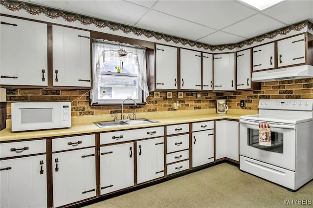 kitchen featuring white appliances, under cabinet range hood, light countertops, white cabinets, and a sink