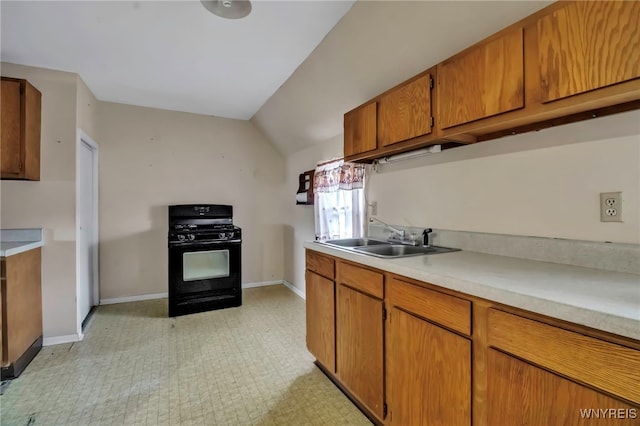 kitchen featuring a sink, brown cabinets, light countertops, black range with gas cooktop, and light floors