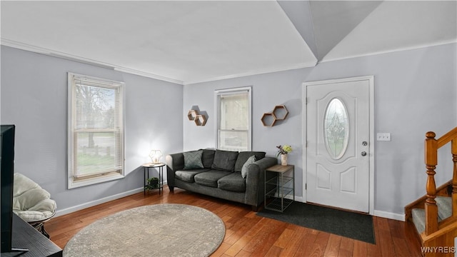 foyer entrance featuring hardwood / wood-style flooring, baseboards, ornamental molding, and stairs