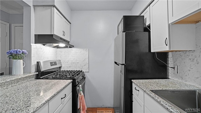kitchen with white cabinets, range with gas cooktop, under cabinet range hood, and backsplash