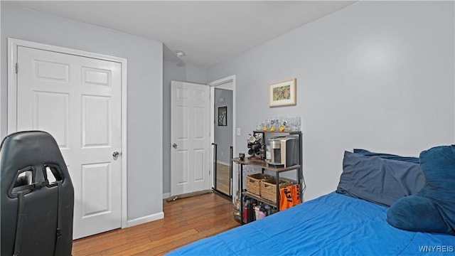 bedroom with baseboards and hardwood / wood-style flooring
