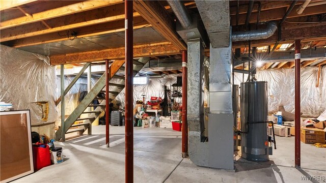 unfinished below grade area with stairway, heating unit, and gas water heater
