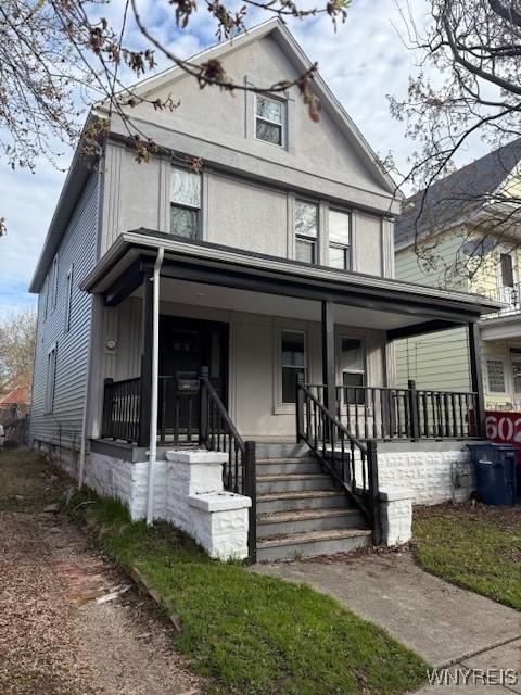 american foursquare style home featuring covered porch