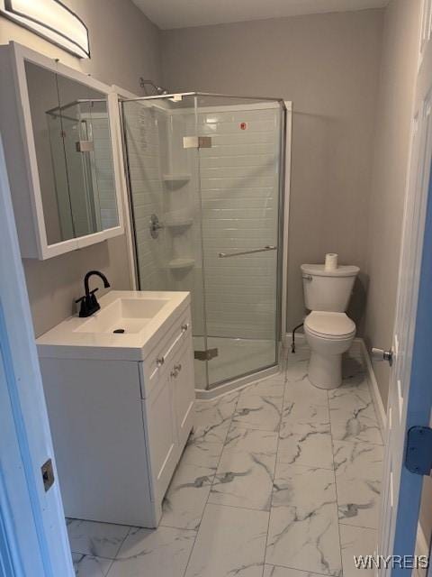 bathroom with toilet, a stall shower, marble finish floor, and vanity