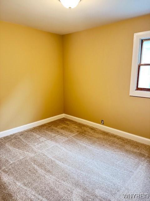 empty room with carpet floors and baseboards