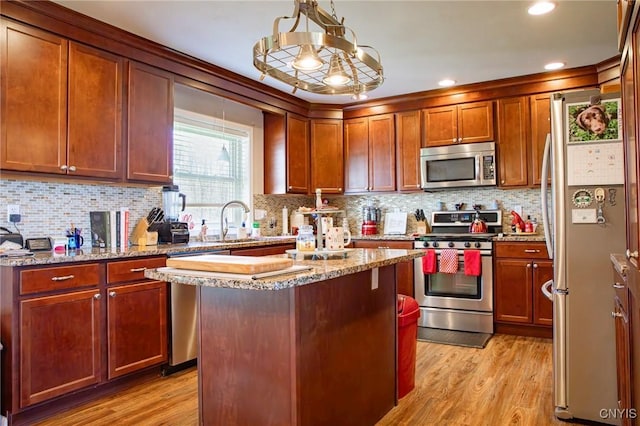 11188 Westdale Rd Unit 6, Florence, NY 13483 - kitchen featuring a kitchen island, light wood-style floors, tasteful backsplash, light stone counters, and appliances with stainless steel finishes