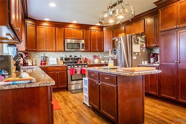 11188 Westdale Rd Unit 6, Florence, NY 13483 - kitchen with light stone countertops, appliances with stainless steel finishes, a sink, and light wood-type flooring