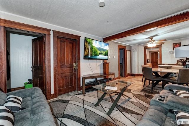living room with baseboards, a ceiling fan, and light wood-style flooring