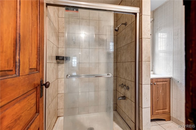 bathroom featuring a stall shower, tile patterned flooring, and tile walls