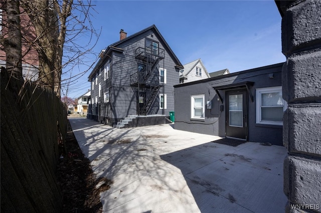 625 22nd St, Niagara Falls, NY 14301 - back of property featuring a patio, a chimney, and stucco siding
