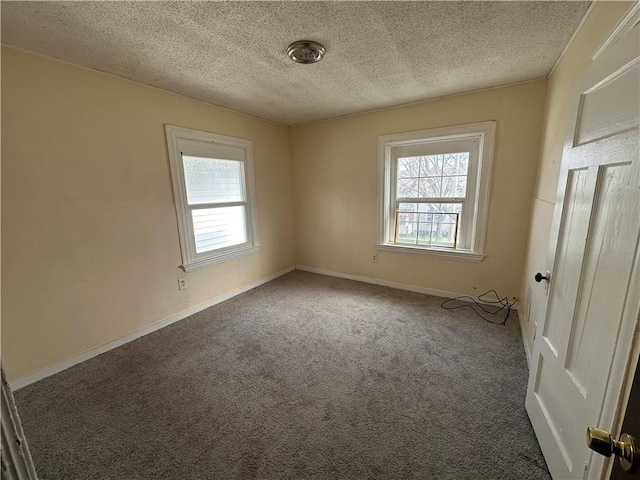 carpeted spare room with baseboards and a textured ceiling