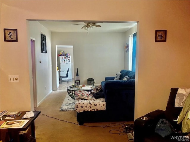 living area featuring a ceiling fan and light colored carpet