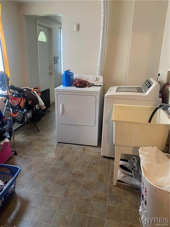 washroom featuring laundry area, a sink, a wealth of natural light, and washer and clothes dryer