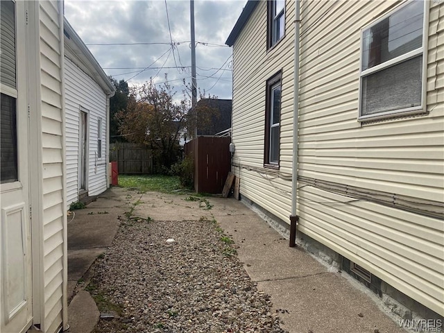 view of side of home featuring fence