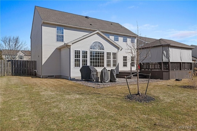 rear view of property with fence and a yard