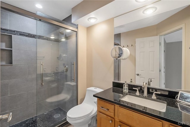 full bath featuring vanity, a stall shower, and toilet