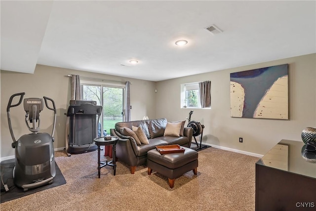 carpeted living area featuring visible vents and baseboards