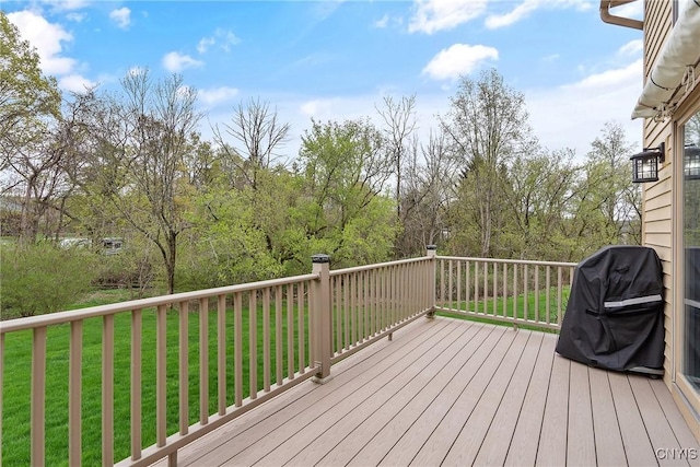wooden terrace featuring a lawn and area for grilling