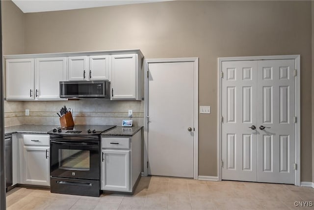 kitchen featuring white cabinets, dark stone countertops, stainless steel microwave, black range with electric cooktop, and backsplash