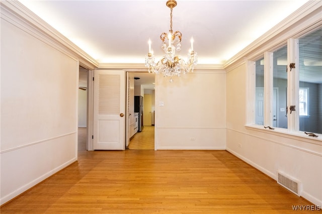 unfurnished room featuring visible vents, light wood-style flooring, baseboards, and a chandelier