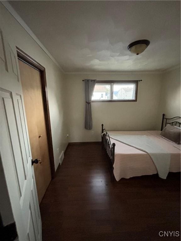bedroom featuring dark wood-style flooring and ornamental molding