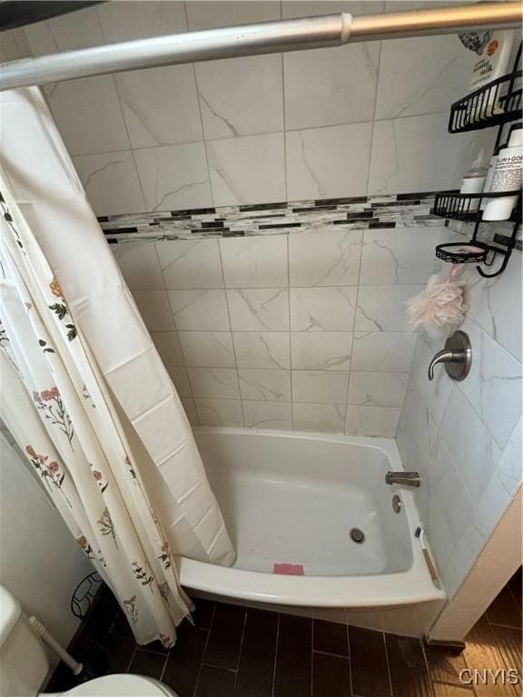 full bath with tiled shower / bath combo and toilet