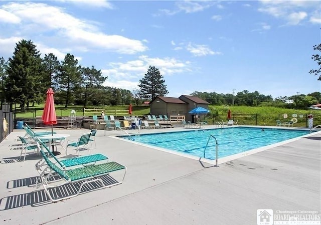 pool with a patio and fence