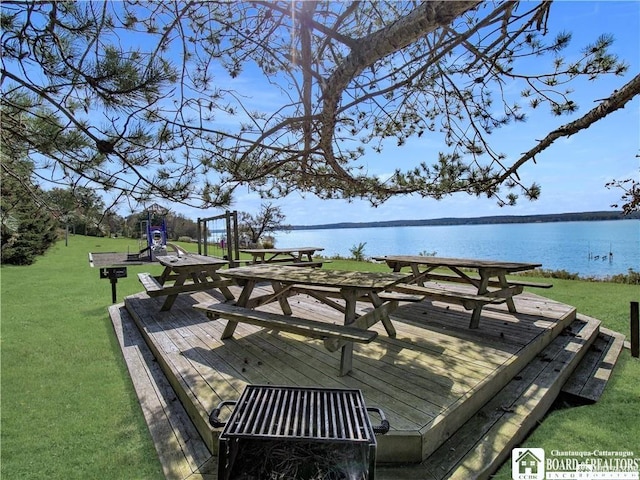 wooden terrace with a yard and a water view
