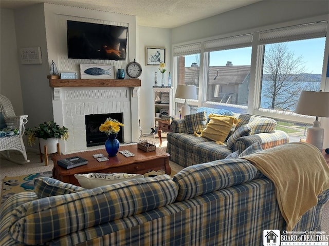living area with a fireplace and a textured ceiling