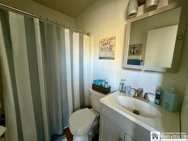 bathroom with toilet, curtained shower, and vanity