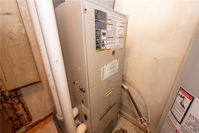 utility room featuring heating unit and water heater