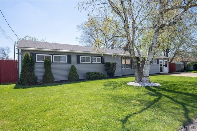 ranch-style home with a chimney, fence, and a front yard