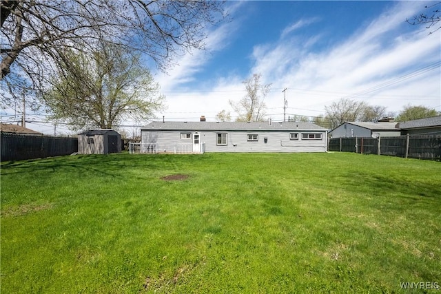 back of property featuring a lawn, a fenced backyard, and a shed