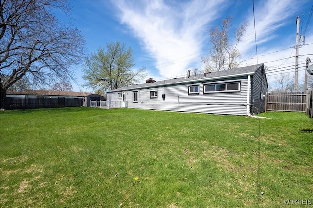 back of property with a yard and fence