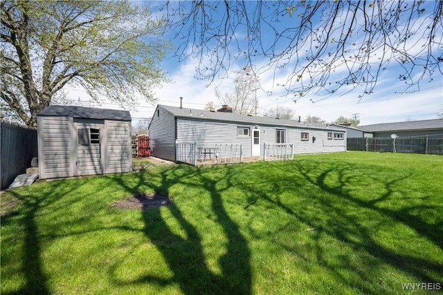 back of property featuring a storage unit, a fenced backyard, a chimney, a lawn, and an outdoor structure