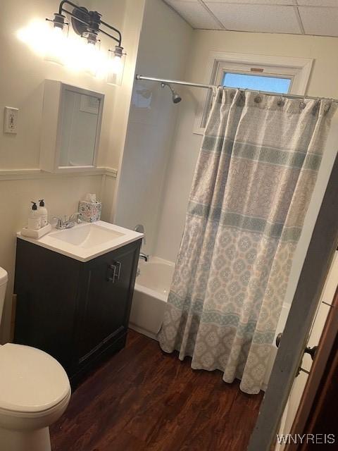 full bathroom featuring wood finished floors, toilet, vanity, and shower / tub combo with curtain