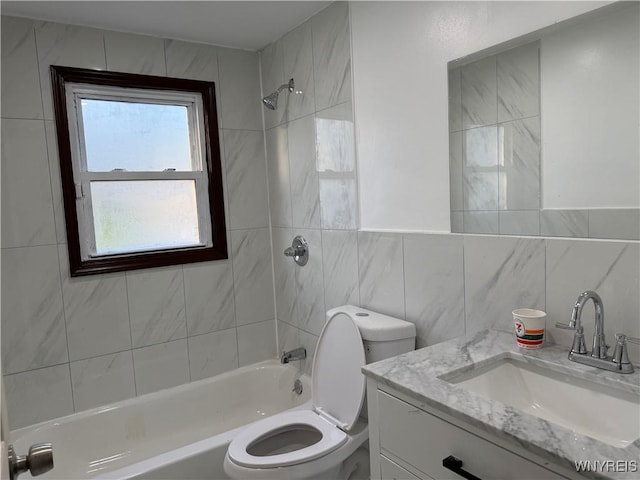 bathroom with vanity, toilet, tub / shower combination, and tile walls