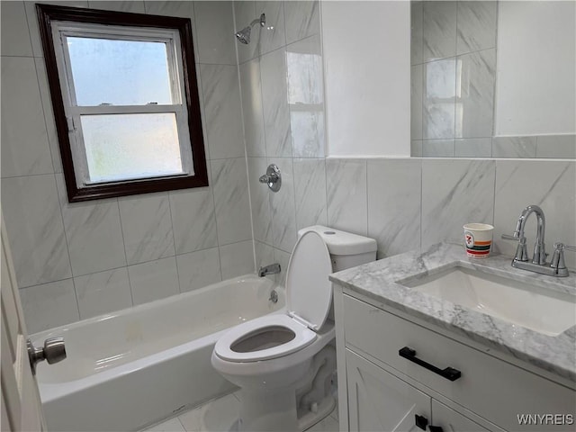 bathroom featuring tile walls, bathing tub / shower combination, toilet, and vanity