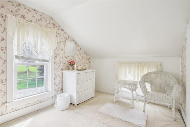 living area with wallpapered walls, vaulted ceiling, and a healthy amount of sunlight